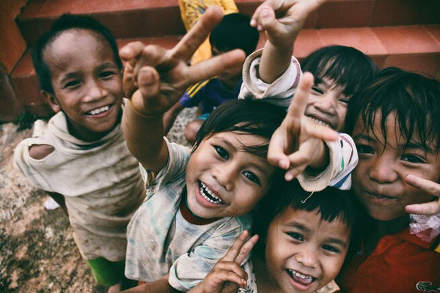 5 Children smiling while doing the peace sign