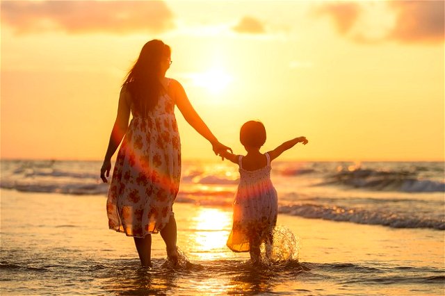 Mother walking with daughter on the beach