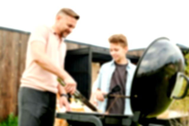 A father grilling outside with his son