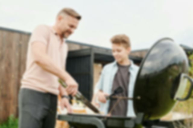 A father grilling outside with his son