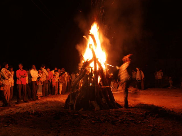 Ahmedabad, India, Circa 2020 - Photograph of a giant bonfire lit for the auspicious festival of lohri or Holi or Holika Dahan. The fire is surrounded by people