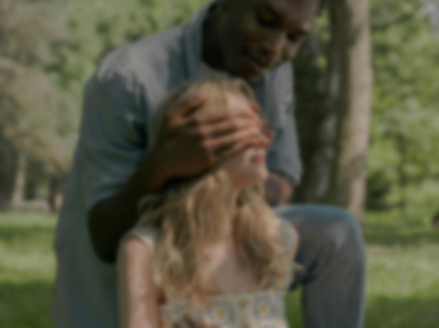 A Woman Covering the Eyes of a Man Using a Handkerchief