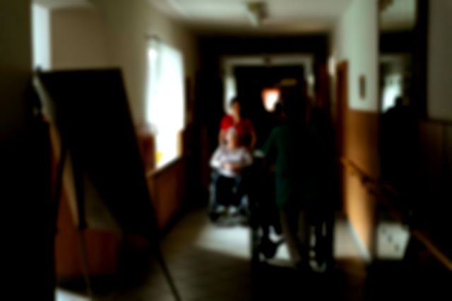 Caregivers Pushing Wheelchairs of Seniors