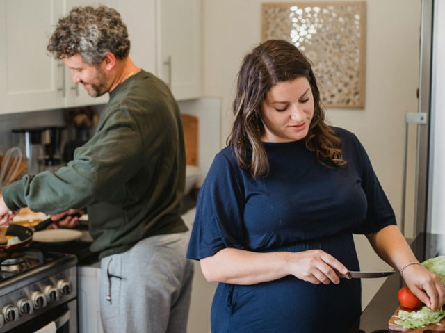 Cheerful couple cooking dinner in kitchen