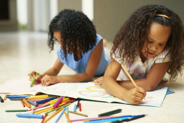 Meninas desenhando deitadas no chão