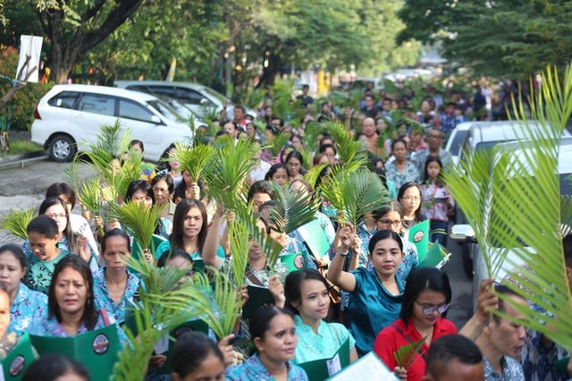 Pessoas com ramos na procissão do Domingo de Ramos