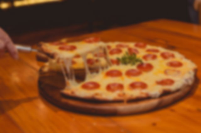 A man cutting a pizza slice