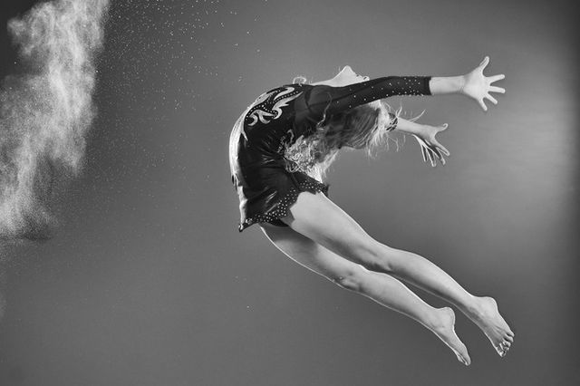 A greyscale image of a child jumping mid air