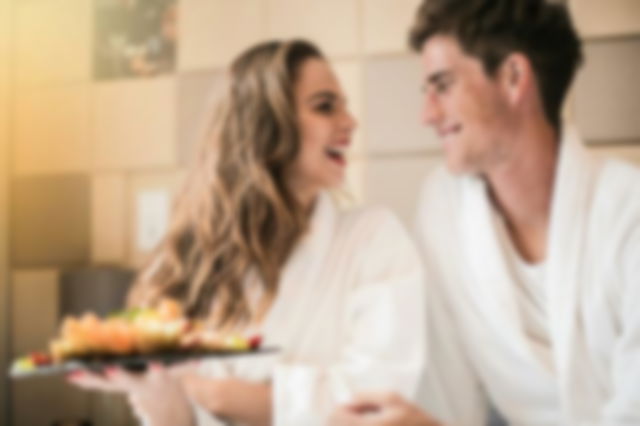 Happy couple with a fruit platter in bedroom