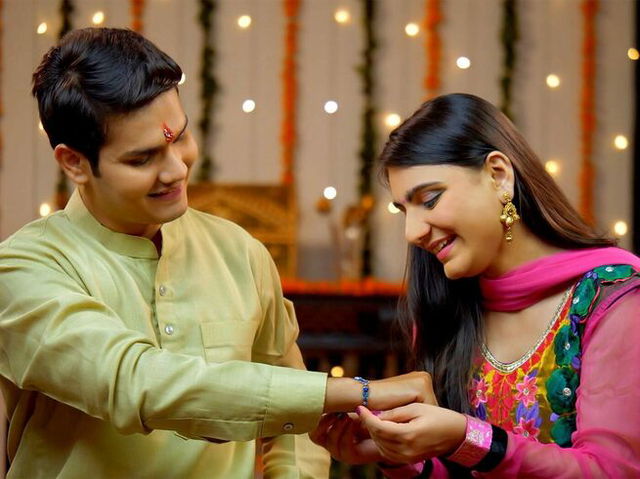 Indian sister tying rakhi on her brother‘s wrist