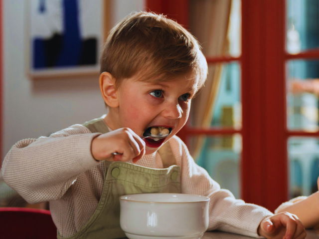 Kid eating cereal and milk