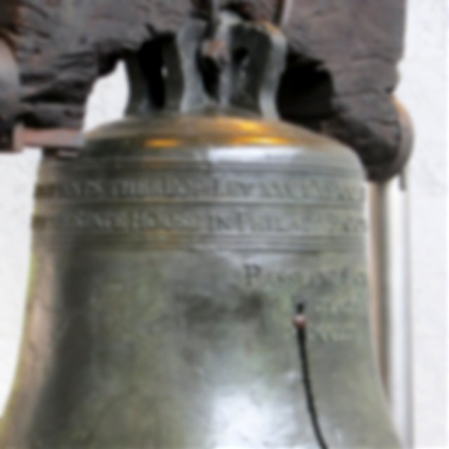A close up of the liberty bell, cracked and hanging from it‘s ancient wooden frame