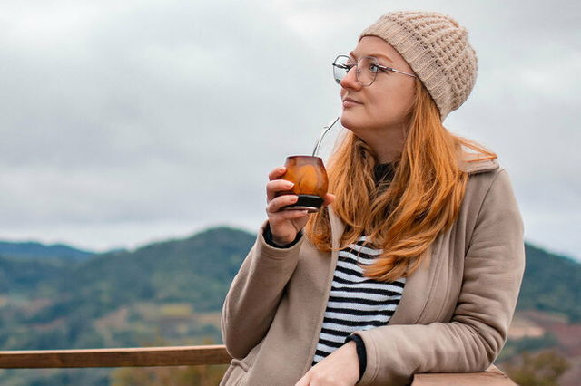 Mulher bebendo chimarrão no inverno