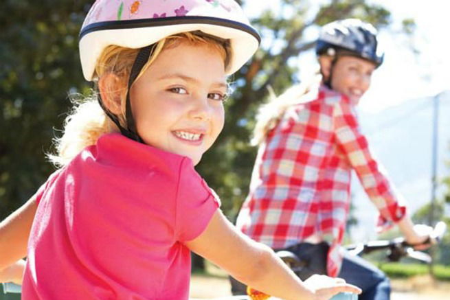 Mãe e filha andando de bicicleta
