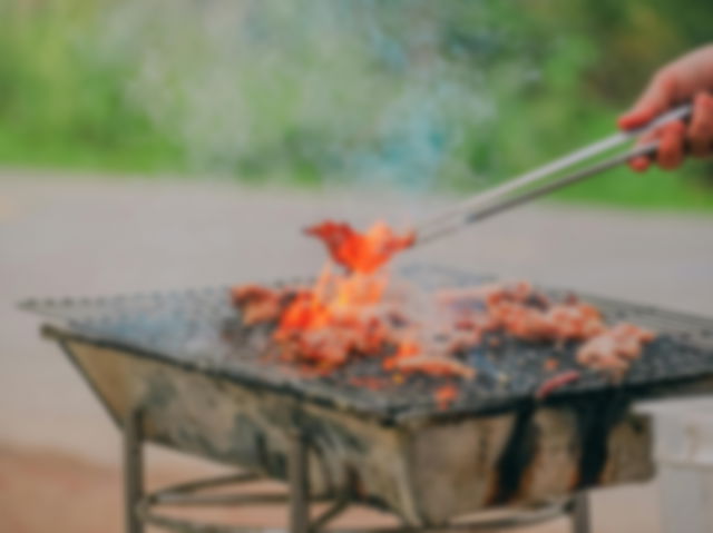 Person Holding Tongs Cooking Barbecue