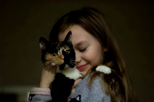 Cute little girl tenderly hugging cat