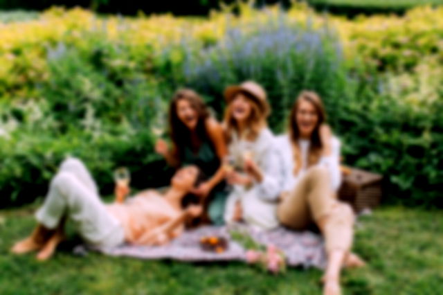 Women Sitting on Green Grass Field