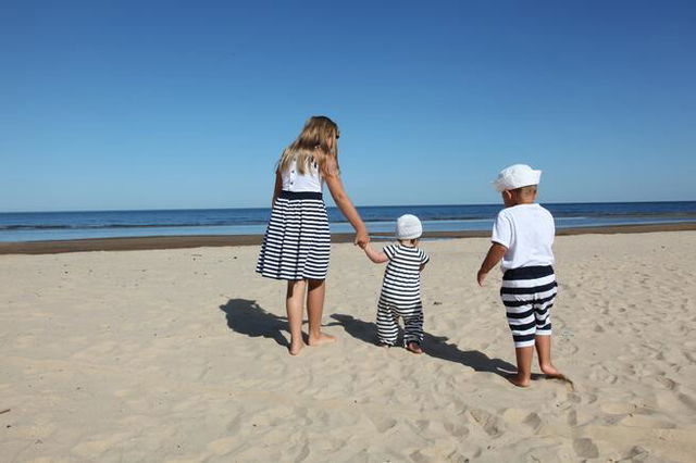 three siblings having fun on the beach