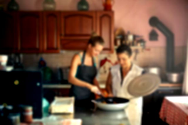 Cheerful women cooking together in kitchen