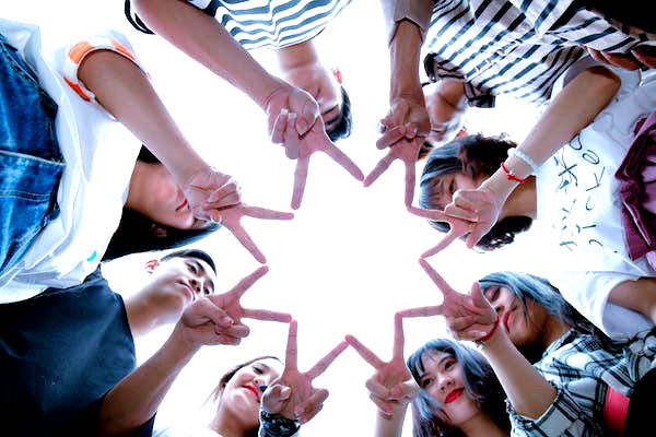 An image of a group of kids using their fingers to form a star to symbolise friendship