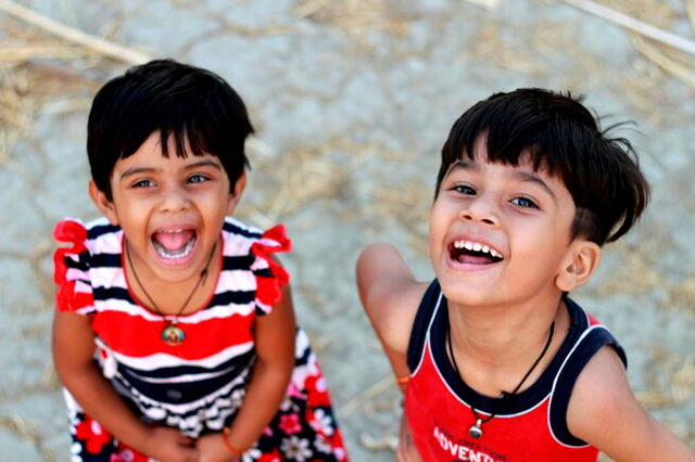 Two Indian toddler cousins smiling and laughing