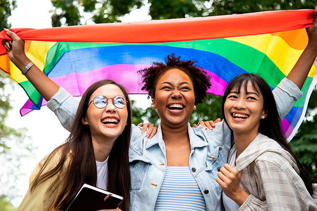 three women with pride flag