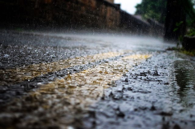 An image of rain drops falling on the ground