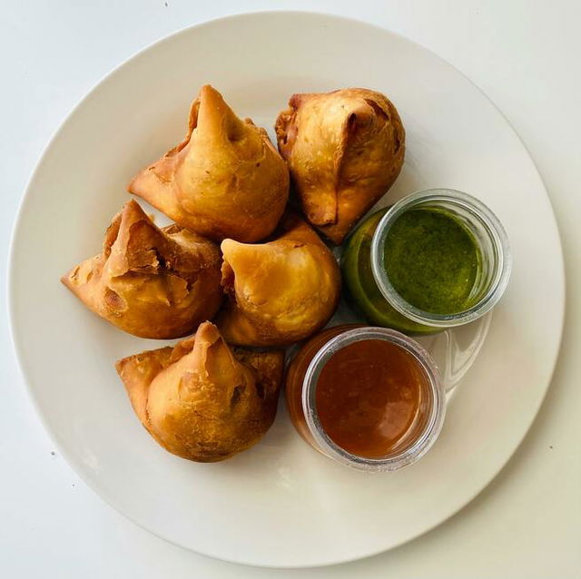 Samosa and chutney on a ceramic plate