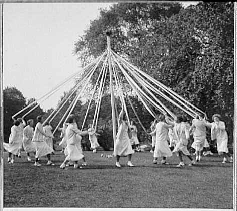 black and white photo of dancing around a maypole
