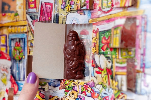 A woman taking a chocolate Santa out of an Advent Calendar