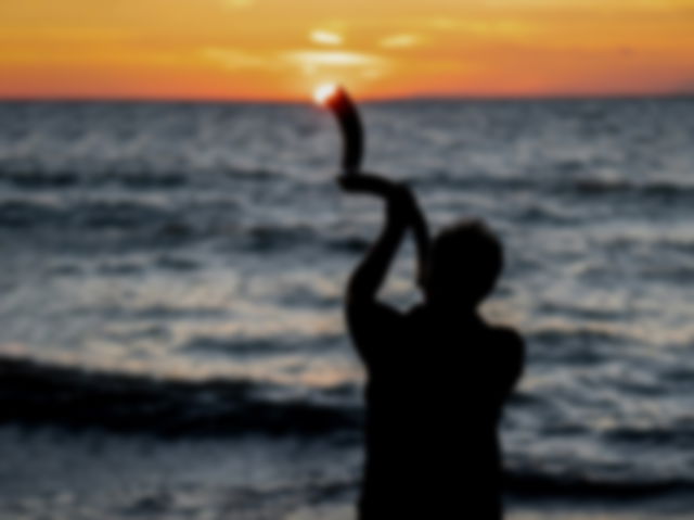 Silhouette of a man blowing shofar