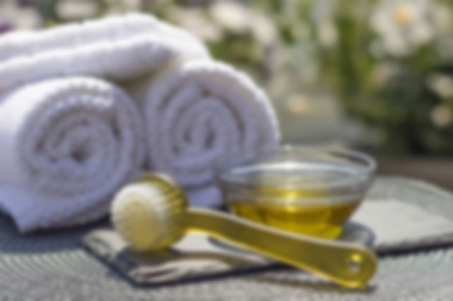 A brush, oil and towels lay on a table