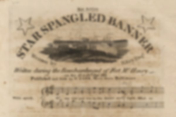 The front cover to the music score of The Star Spangled Banner. Sepia paper and faded print, stars and images decorate it