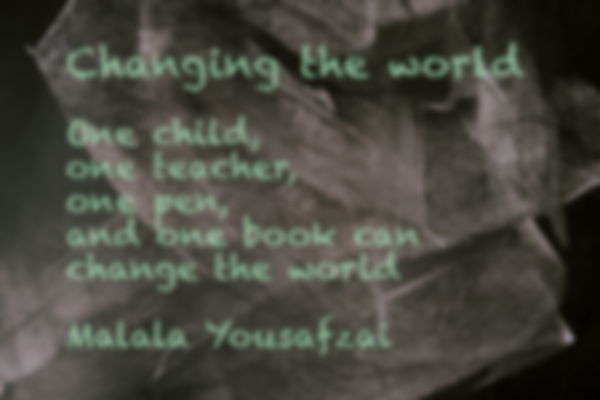 A black chalkboard with with a quote from Malala Yousafzai about education in pale blue writing