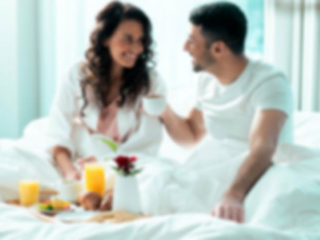 Couple eating breakfast while smiling at each other