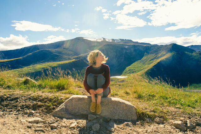 Woman sitting among the mountains in nature