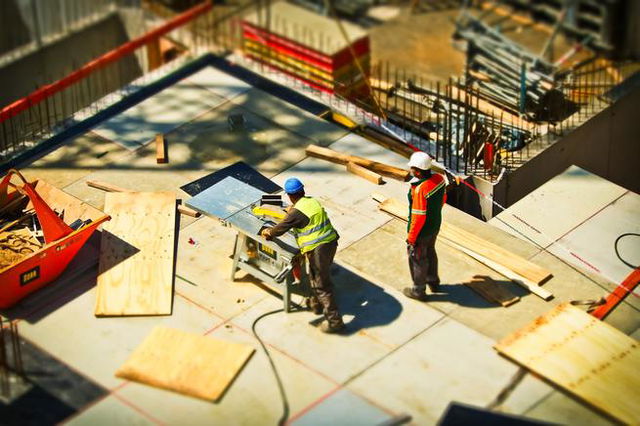 dos trabajadores en una obra con casco y equipamientos de protección