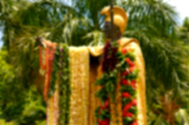 a statue of Kamehameha decorated in colorful leis