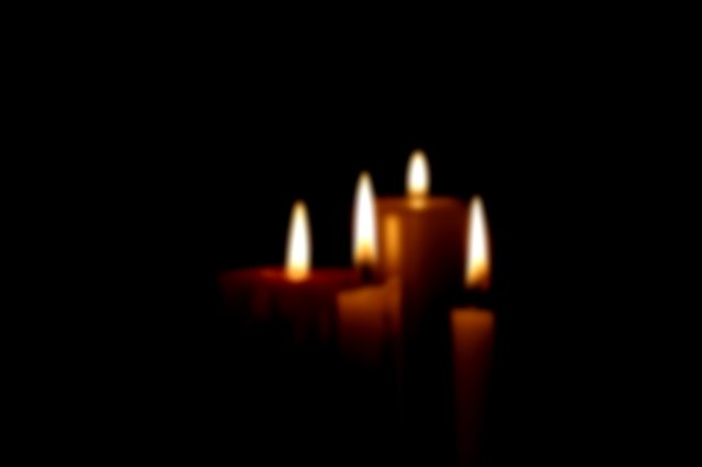 Four candles lighting up a dark room
