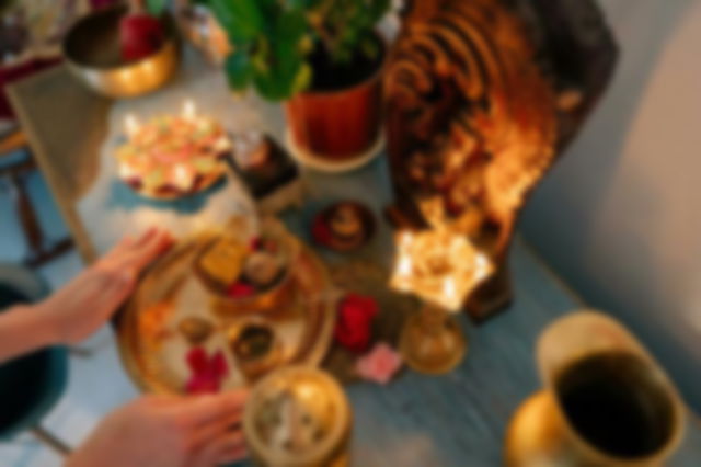 A Person Putting Golden Plate with sweets on the Altar