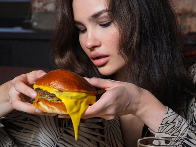 A woman eating cheeseburger