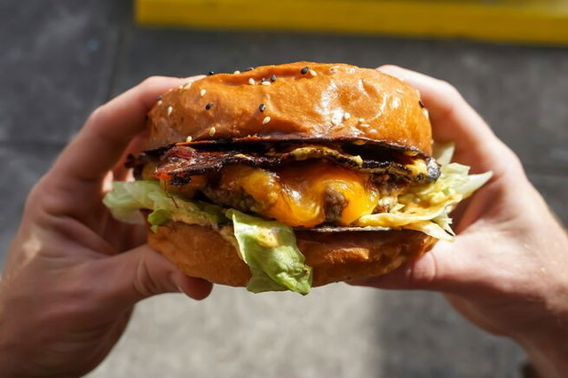 A person holding a burger