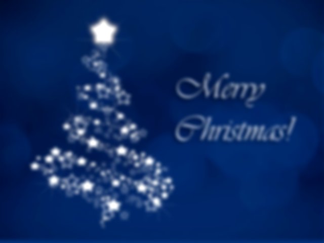 The words Merry Christmas in silver with a silver Christmas tree on a dark blue background