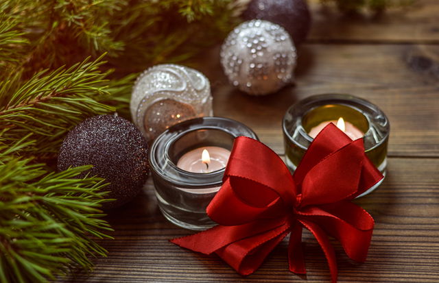 Adornos de Navidad junto a una vela sobre la mesa