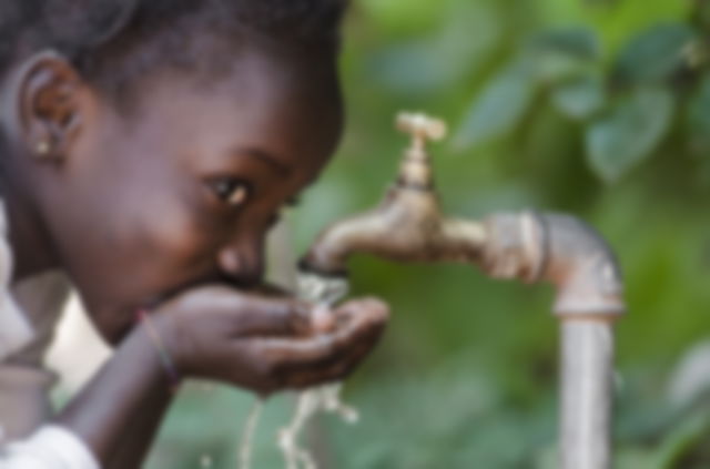 niña bebiendo agua con sus manos