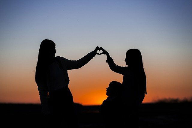 Imagen de tres hermanos ante una puesta de sol