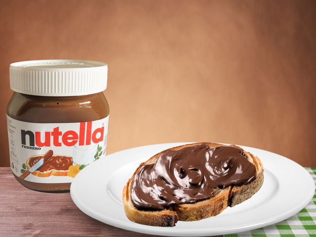 D&iacute;a Mundial de la Nutella: tostada de pan con nutella sobre plato con mantel a cuadros verdes