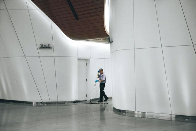 A custodian cleaning the floor of a building.