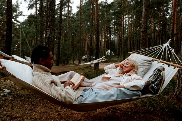 two people laying down and relaxing in a hammock