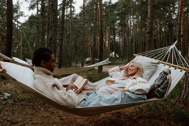 two people laying down and relaxing in a hammock